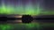 Dancing Northern lights Aurora borealis in autumn over beautiful lake and island at night.