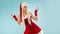 Dancing snow maiden. Charming and attractive blonde woman in a Santa suit.