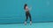 Dancing woman perform expressive dance walking on blue background outside. Girl in sunglasses dancer cool moving