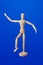 Dancing wooden toy figure on blue