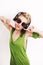 Dancing young woman wearing headphones and sunglasses