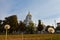 Dandelion seedheads with ripe seed in a yard, Dormition of the Mother of God Orthodox church in background