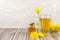 Dandelion tea and honey on wooden background. Transparent glass cup of hot healthy herbal tea with fresh yellow blossoms