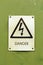 Danger electricity sign on a green background