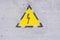 Danger of electrocution yellow sign on painted wall. High voltage warning sign