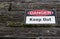 Danger, keep out warning sign over old weathered rustic wooden t
