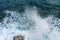Danger ocean wave crashing on rock coast with spray and foam bef