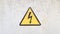 Danger sign of high voltage electricity. Yellow triangular sign with a lightning in the center. This warning is written on an old