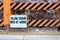 Danger sign on orange black slope protection with mountain rocks background. Natural disaster