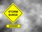 Danger storm surge road sign . Yellow hazard warning sign against grey sky