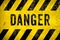 DANGER warning sign word text yellow black stripes concrete wall cement texture background. Danger dangerous warning