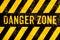 Danger zone warning sign text with yellow and black stripes painted over concrete wall surface facade cement texture background