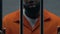 Dangerous African-American criminal holding prison bars, imprisonment, close-up