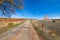 Dangerous curve sign on rural road with potholes