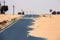 Dangerous desert road with sand mound and sign about just one way driving windy sandy dunes