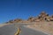 Dangerous hairpin curve in two lane highway with rocks piled on horizon above the tree line on Pikes Peak in Colorado