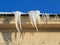 Dangerous icicles in winter on the roof of the house