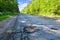 Dangerous pothole in the asphalt rural road. Road damage.