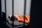 A dangerous prisoner in a cell rests and sleeps in a solitary cell on a bunk in an orange robe.