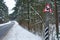 Dangerous section of snowy road in winter, road sign