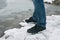 Dangerous thin ice. Man takes risk to step on frozen river surface in winter. Caution. unsafe water