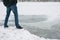 Dangerous thin ice. Man takes risk to step on frozen river surface in winter. Caution. unsafe water