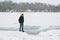 Dangerous thin ice. Man takes risk to step on frozen river surface in winter. Caution. unsafe water