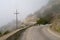 Dangerous winding road in the mountains in a fog.