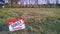 Danish property sold sign in grassy field