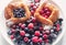 Danish with raspberries and blueberries on  round plate with berries on  white table