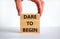 Dare to begin symbol. Wooden blocks with words `Dare to begin`. Beautiful white background, businessman hand. Business, dare to