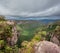 Daredevil Posing as Superman on a Cliff Edge with Forest View