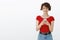 Daring confident young cheeky girl short pixie haircut wear red t-shirt hold smartphone smiling satisfied self-assured