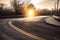 Dark asphalt road with bright yellow lines curves under sunset