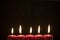 Dark background with five Christmas candles