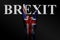 On a dark background, a hand with a painted UK flag and the word BREXIT shows a goat sign, a symbol of mainstream, metal and rock