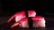 On a dark background on a tray, cooked or purchased sushi Nigiri taste Chinese chopsticks. Concept of: Nigiri, Sushi of the Day,