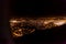 Dark background view of city with lights from aeroplane. Night lights in the city. Aeroplane view of dark nigh above the