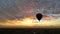 Dark balloon raising to the sky at dawn