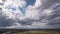 Dark beautiful clouds, dramatic sky over a beautiful valley. The clouds are moving forward. 4k timelapse.