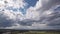 Dark beautiful clouds, dramatic sky over a beautiful valley. The clouds are moving forward. 4k timelapse.