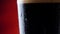 Dark Beer closeup. Pint of cold Craft beer rotation. Glass of beer with water drops.