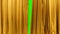 a dark beige theatrical curtain moves apart behind it a green background