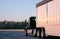 Dark big rig semi truck with day cab carry huge bulk trailer run