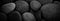 Dark black abstract smooth round pebbles texture background