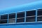 Dark black windows of a blue bus against blue sky background. Military bus for soldiers or police swat arrival.