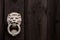 Dark black wooden background with lion shaped door knocker and c