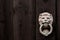 Dark black wooden background with lion shaped door knocker and s