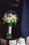 Dark blue bow tie on a luxury bridal bouquet of white flowers on a shelf