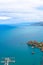 Dark blue calm water of Tyrrhenian sea surrounding the Sicilian coastal village Cefalu from above. Captured on vertical picture